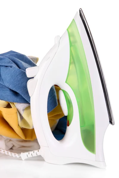 Ijzer en stapel van kleurrijke kleding op wit wordt geïsoleerd — Stockfoto