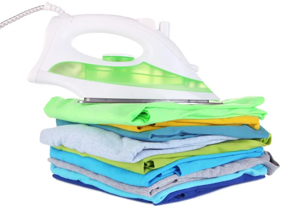 Iron on pile of colorful clothes isolated on white — Stock Photo, Image