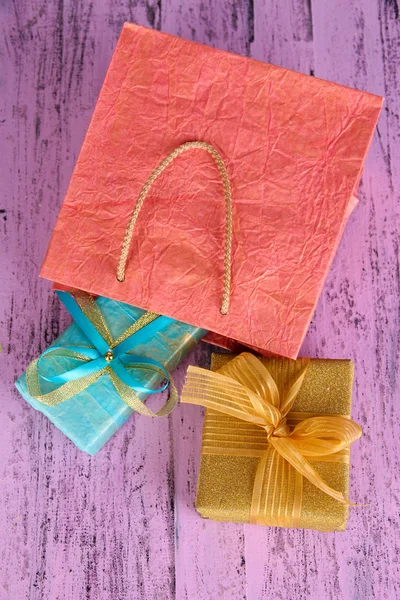 Presents with paper bag on wooden background