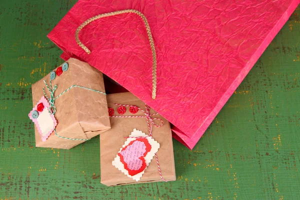 Presents with paper bag on wooden background — Stock Photo, Image