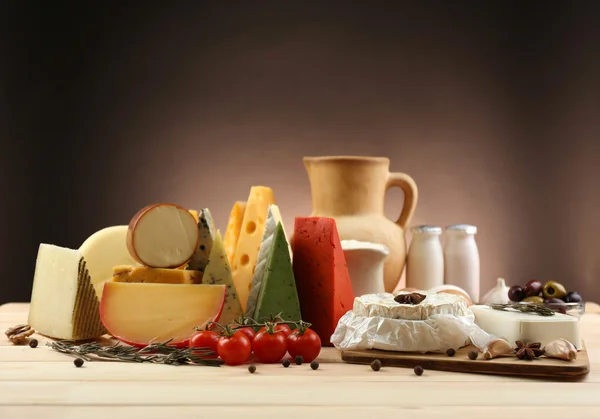 Tasty dairy products on wooden table, on dark background — Stock Photo, Image