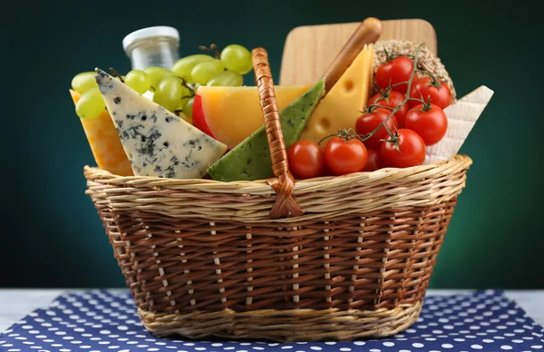 Basket with tasty dairy products on dark background — Stock Photo, Image