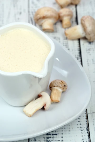 Delicate mushroom sauce in pitcher on wood table close-up — Stok Foto