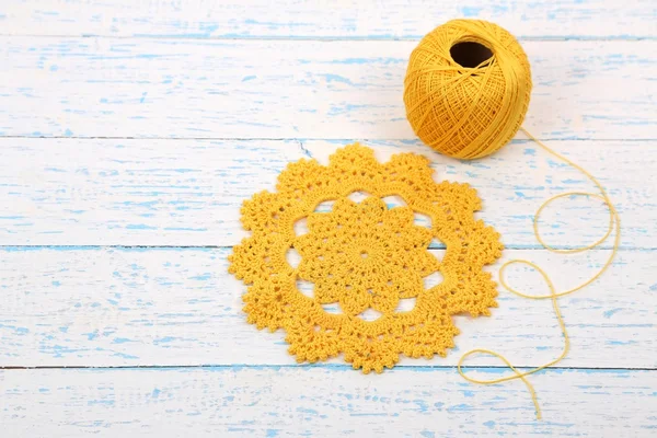 Yellow yarn for knitting with napkin and spokes on wooden table close-up — Stock Photo, Image