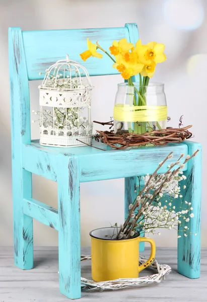 Beautiful spring flowers on blue old wooden chair — Stock Photo, Image