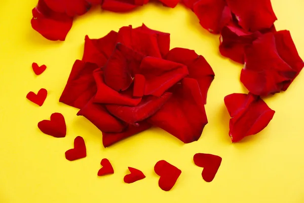 Krásné červené lístky růží, na žlutém podkladu — Stock fotografie