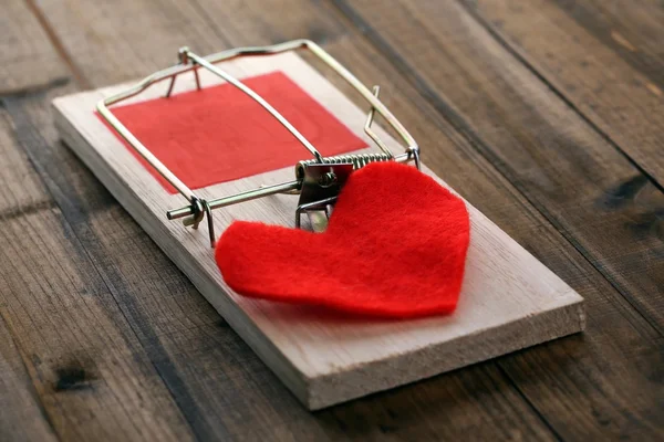 Mousetrap with heart on wooden background — Stock Photo, Image