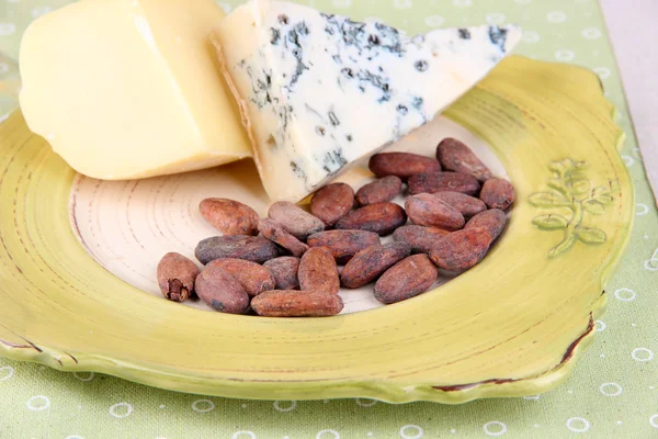 Prato de queijo variado, grãos de cacau, close-up — Fotografia de Stock