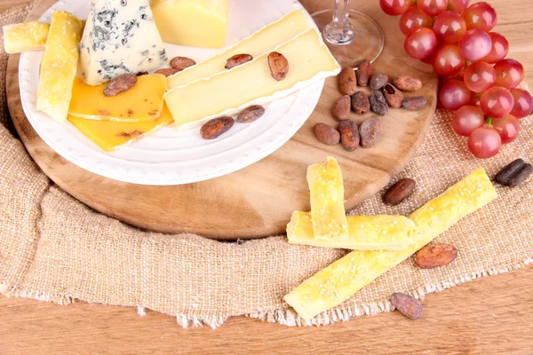 Prato de queijo sortido no fundo da mesa — Fotografia de Stock