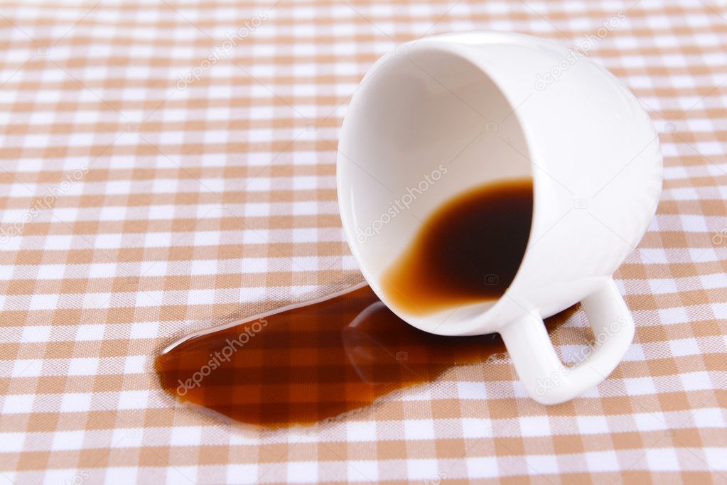 Overturned cup of coffee on table close-up