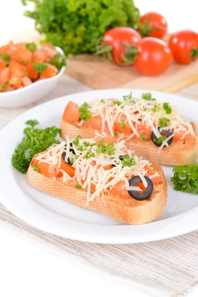 Köstliche Bruschetta mit Tomaten auf dem Teller in Großaufnahme — Stockfoto