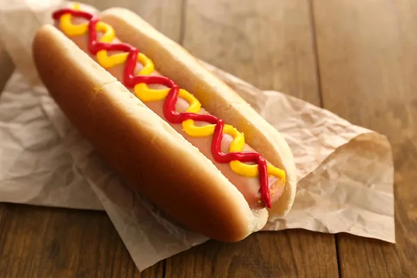 Tasty hot dog on wooden table