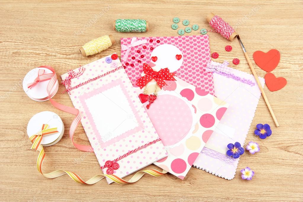 Beautiful hand made post cards and scrapbooking elements, on wooden table