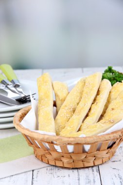 hasır sepet üzerinde açık renkli ahşap masa üstünde ekmek sopa