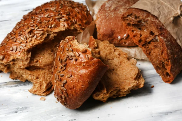 Partir o pão na mesa de madeira — Fotografia de Stock