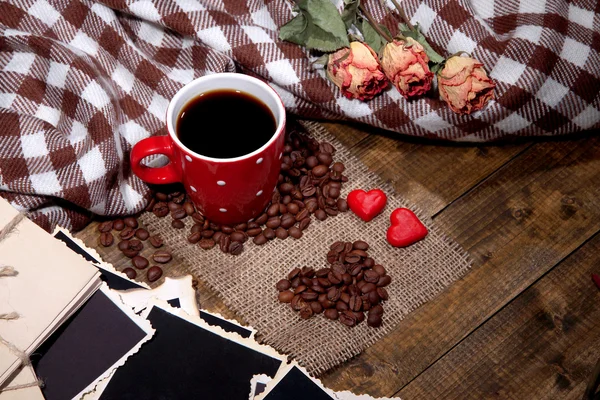 Composition with coffee cup, decorative hearts, plaid spices and old blank photos, on wooden background — Stock Photo, Image