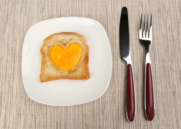 Scrambled eggs with bread on plate, on color napkin — Stock Photo, Image