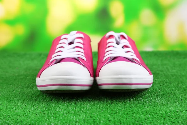 Belle scarpe da ginnastica su erba verde, su sfondo luminoso — Foto Stock