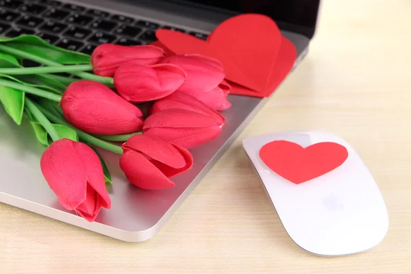 Ordenador con corazones rojos y flores en la mesa de cerca — Foto de Stock