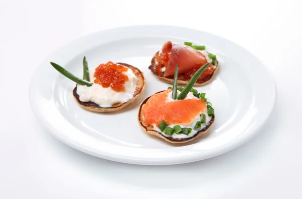 Frittelle con caviale rosso e salmone, isolate su bianco — Foto Stock