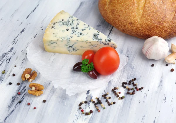 Queijo azul saboroso e pão na velha mesa de madeira — Fotografia de Stock