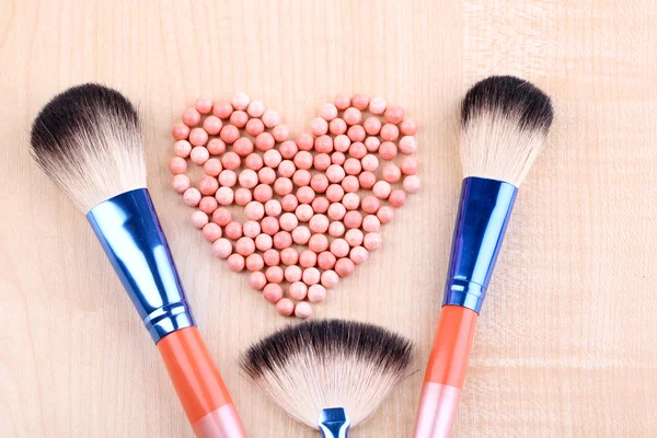 Powder balls and brushes on wooden background