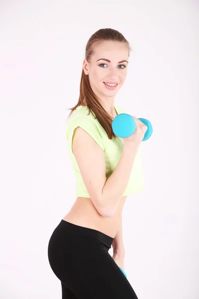 Joven hermosa chica de fitness haciendo ejercicio con pesas en el gimnasio — Foto de Stock