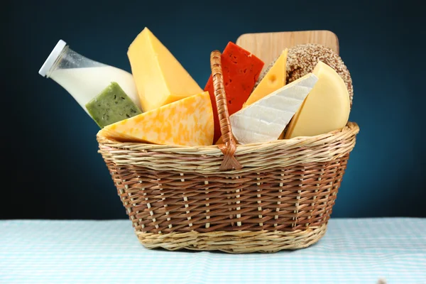 Basket with tasty dairy products on blue background — Stock Photo, Image