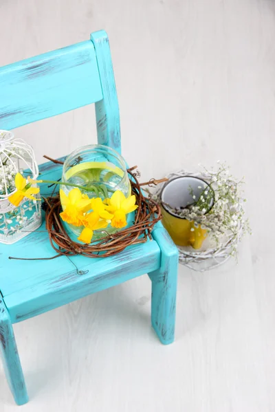 Piękne wiosenne kwiaty na niebieski stare drewniane krzesło — Zdjęcie stockowe