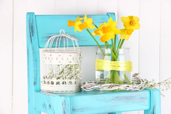 Hermosas flores de primavera en silla de madera azul vieja — Foto de Stock