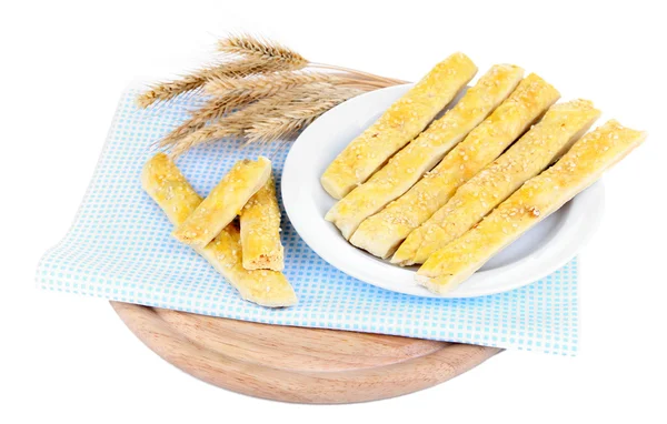 Välsmakande bröd pinnar på plattan på färg Servett, isolerad på vit — Stockfoto
