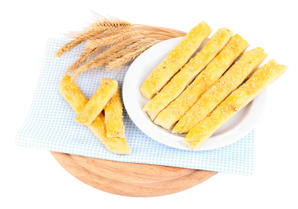 Tasty bread sticks on plate on color napkin, isolated on white — Stock Photo, Image