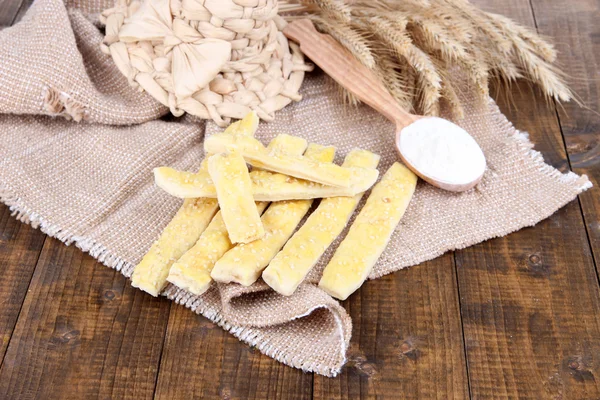 Bread sticks on sackcloth on wooden background — Stock Photo, Image