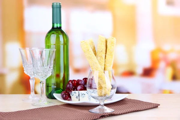 Druivenmost, kaas en brood stokken op plaat op houten tafel, op lichte achtergrond — Stockfoto