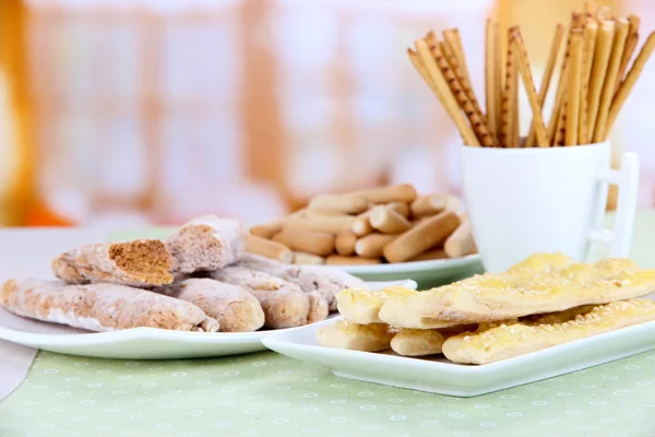 Varietà di bastoncini di pane sul tavolo, su sfondo luminoso — Foto Stock