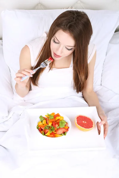 Jonge mooie vrouw in bed met licht ontbijt — Stockfoto