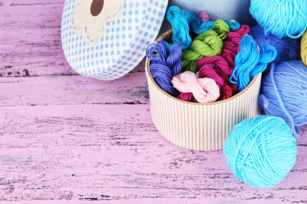 Decorative boxes with colorful skeins of thread on wooden background — Stock Photo, Image