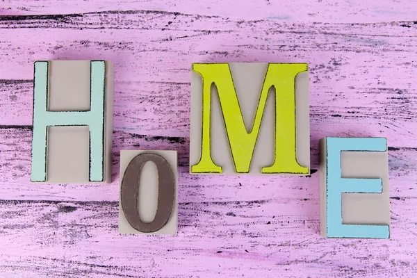 Letras decorativas formando palabra HOME sobre fondo de madera —  Fotos de Stock