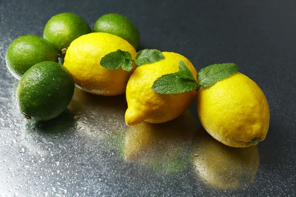 Limoni e lime su fondo scuro — Foto Stock