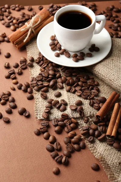 Coffee beans and cup of coffee on table close-up Stock Photo