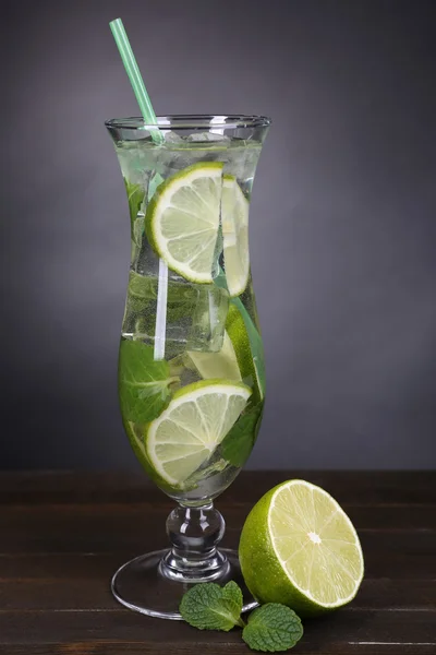 Verre de cocktail avec citron vert et menthe sur la table sur fond gris — Photo