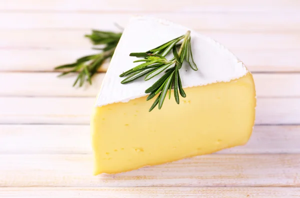 Schmackhafter Camembert-Käse mit Rosmarin, auf Holztisch — Stockfoto