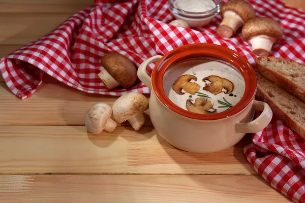 Sopa de champiñones en olla, en servilleta, sobre fondo de madera — Foto de Stock