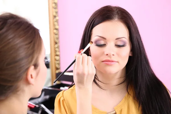 Ung kvinna stylist gör makeup vacker flicka i skönhetssalong — Stockfoto
