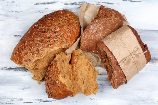 Partir o pão na mesa de madeira — Fotografia de Stock