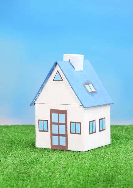 Little house on green grass, on bright background — Stock Photo, Image