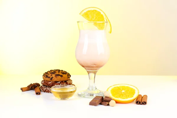 Eggnog with spices and orange on yellow background — Stock Photo, Image