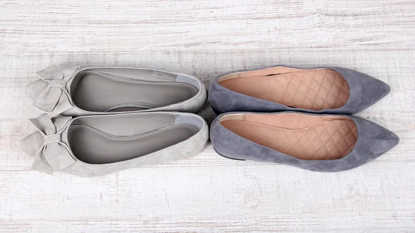 Vackra grå kvinnligt skor på trä bakgrund — Stockfoto