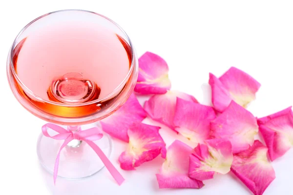 ガラスと白で隔離されるバラの花びらのピンクの輝きのワインと組成 — ストック写真
