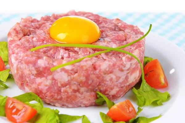 Delicious steak tartare with yolk on plate on table close-up — Stock Photo, Image